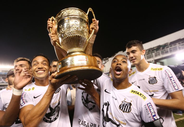 Jogadores do Santos Futebol Clube comemorando título com troféu após conquista histórica