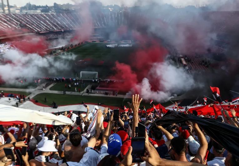 Torcida do São Paulo Futebol Clube no Estádio do Morumbi durante jogo histórico, com bandeiras e fumaça nas arquibancadas